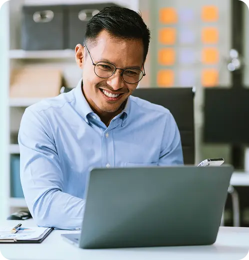 Homem em uma mesa de escritório usando o computador.